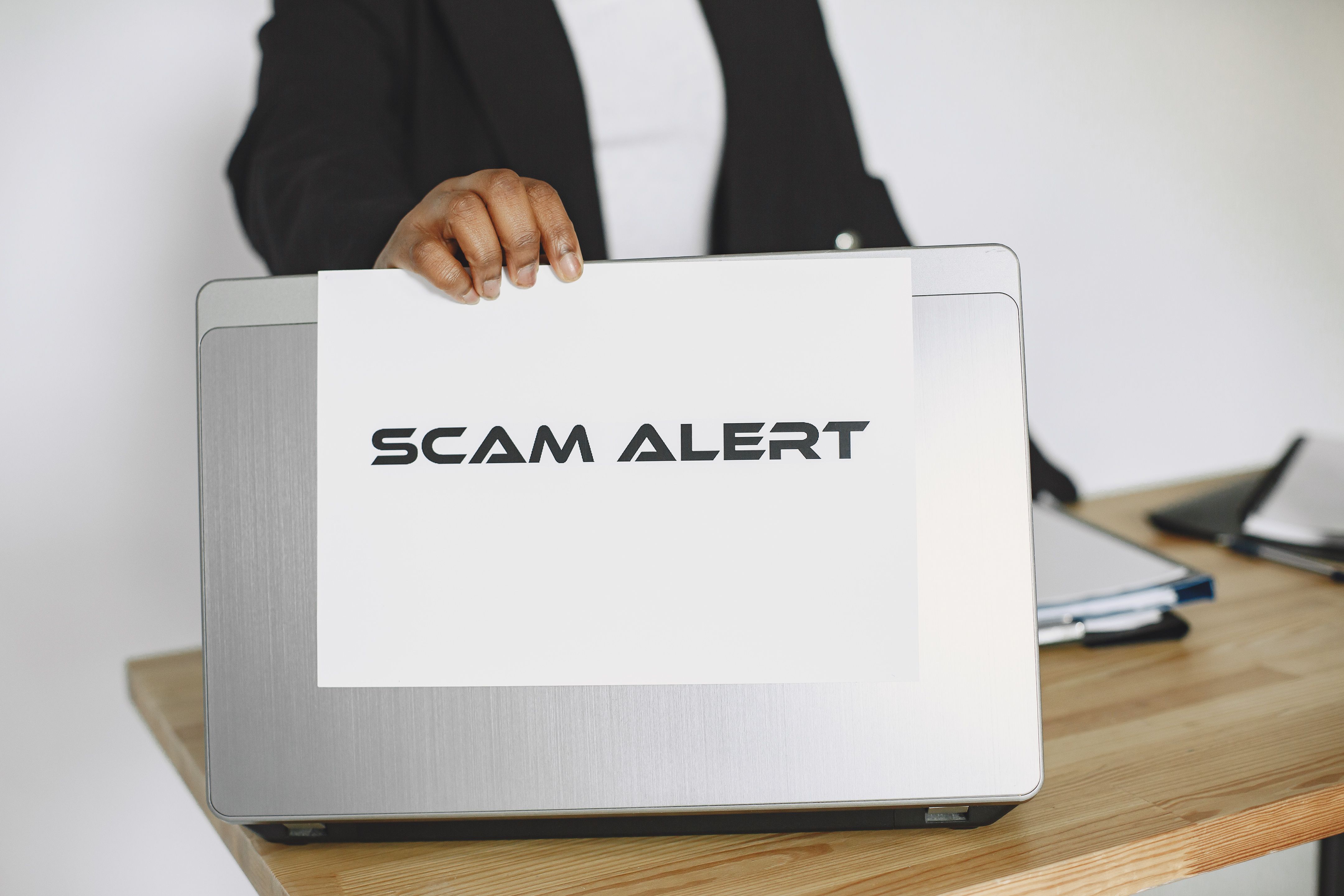 SCAM ALERT sign held up as a fraud warning